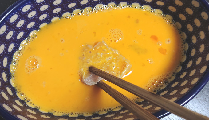鶏肉を溶き卵にくぐらせているところ
