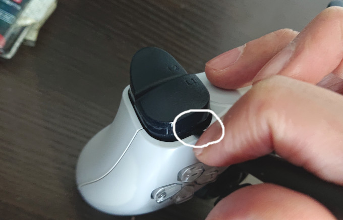 精密ドライバーでプレステ5コントローラーのL1ボタンを外しているところ