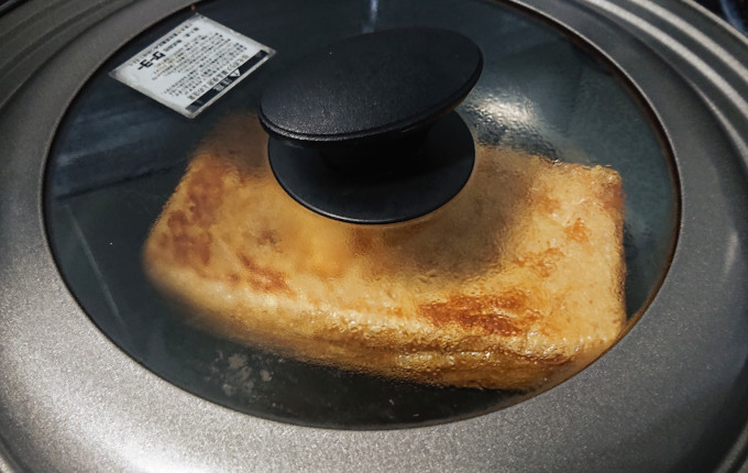 フライパンに蓋をして焼いている栃尾名産 越後あぶらげ